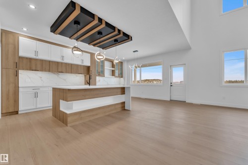 Kitchen featuring glass fronted cabinets, pendant lighting, two tone cabinetry, light wood-type flooring, and open shelves - 202 Basin Court, Leduc, AB - Indoor