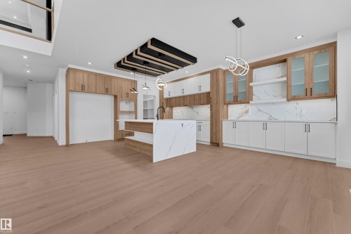 Kitchen with open shelves, hanging light fixtures, light wood-style flooring, and an island with sink - 202 Basin Court, Leduc, AB - Indoor Photo Showing Kitchen