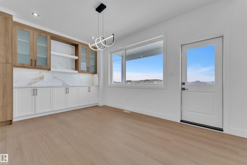 Unfurnished dining area featuring light wood finished floors and hanging lights - 202 Basin Court, Leduc, AB - Indoor
