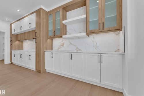 Dual tone kitchen with open shelves, light wood-style flooring, glass fronted cabinets, recessed lighting, and tasteful backsplash - 202 Basin Court, Leduc, AB - Indoor