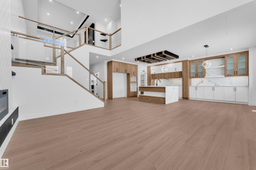 Unfurnished living room featuring light wood-style flooring, recessed lighting, and a high ceiling - 202 Basin Court, Leduc, AB - Indoor Photo Showing Other Room