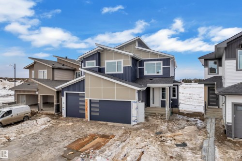 View of front facade featuring board and batten siding - 202 Basin Court, Leduc, AB - Outdoor With Facade