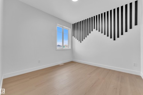 Empty room featuring baseboards and light wood-style floors - 202 Basin Court, Leduc, AB - Indoor Photo Showing Other Room