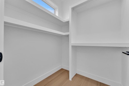 Walk in closet with light wood-type flooring - 202 Basin Court, Leduc, AB - Indoor