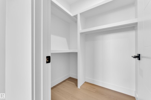 Walk in closet with light wood finished floors - 202 Basin Court, Leduc, AB - Indoor Photo Showing Other Room