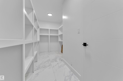 Walk in closet featuring light marble finish floors - 202 Basin Court, Leduc, AB - Indoor With Storage