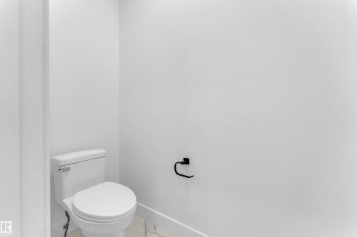 Bathroom featuring baseboards and marble look tile flooring - 202 Basin Court, Leduc, AB - Indoor Photo Showing Bathroom