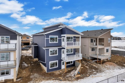 Snow covered back of property with a residential view and a balcony - 202 Basin Court, Leduc, AB - Outdoor