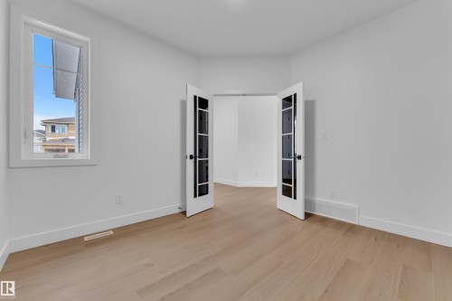 Unfurnished room with light wood-style flooring - 202 Basin Court, Leduc, AB - Indoor Photo Showing Other Room