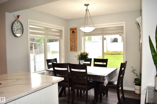 Dining space with dark wood-style flooring, a textured ceiling, and healthy amount of natural light - 315 Wild Rose Way, Edmonton, AB - Indoor Photo Showing Dining Room