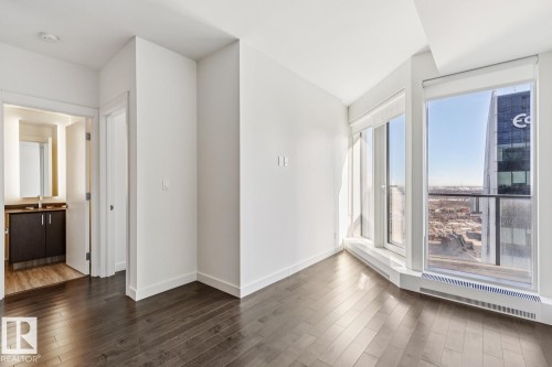 Empty room featuring baseboards and dark wood-style floors - 3104 10360 102 Street, Edmonton, AB - Indoor Photo Showing Other Room
