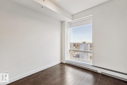 Spare room featuring a baseboard heating unit and dark wood finished floors - 3104 10360 102 Street, Edmonton, AB - Indoor Photo Showing Other Room