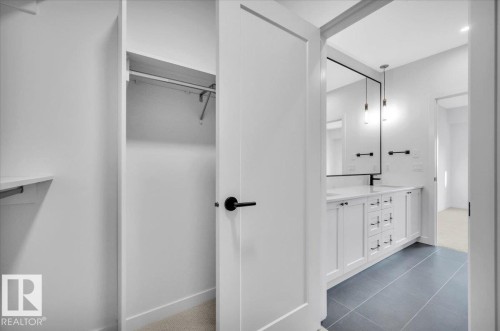 WITH CUSTOM SHELVING AND HANGING BARS - 322 7459 May Common Nw, Edmonton, AB - Indoor Photo Showing Other Room