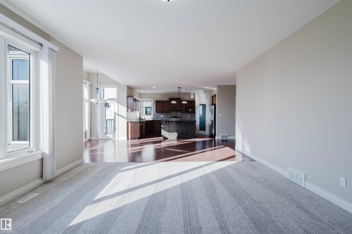 Unfurnished living room featuring dark carpet and baseboards - 3612 Mclay Court, Edmonton, AB - Indoor