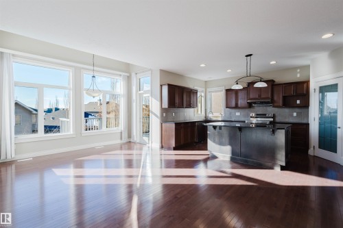 Kitchen featuring a kitchen breakfast bar, pendant lighting, dark wood-style flooring, a kitchen island, and dark wood finish cabinetry - 3612 Mclay Court, Edmonton, AB - Indoor Photo Showing Kitchen