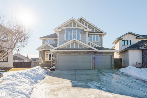 Craftsman-style home featuring stone siding, a garage, and driveway - 3612 Mclay Court, Edmonton, AB - Outdoor With Facade