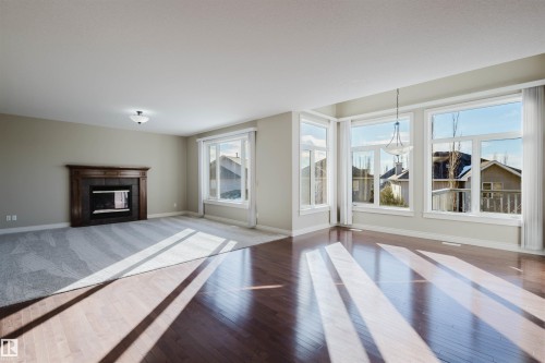Unfurnished living room with a tile fireplace and hardwood / wood-style flooring - 3612 Mclay Court, Edmonton, AB - Indoor Photo Showing Living Room With Fireplace