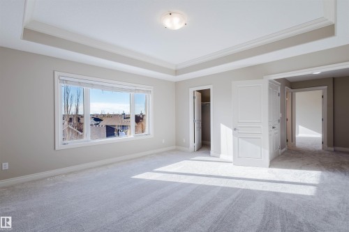 Unfurnished bedroom with ornamental molding, carpet flooring, and a raised ceiling - 3612 Mclay Court, Edmonton, AB - Indoor