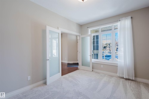 Empty room with carpet floors and french doors - 3612 Mclay Court, Edmonton, AB - Indoor Photo Showing Other Room