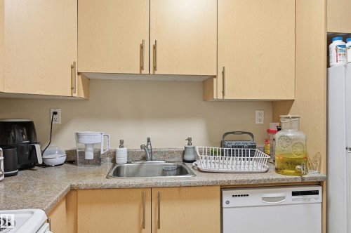 Kitchen with light wood finish cabinetry, light countertops, and white appliances - 302 2624 Mill Woods Road E, Edmonton, AB - Indoor Photo Showing Kitchen