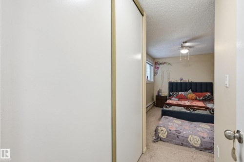 Bedroom featuring light colored carpet, a textured ceiling, and baseboard heating - 302 2624 Mill Woods Road E, Edmonton, AB - Indoor Photo Showing Other Room