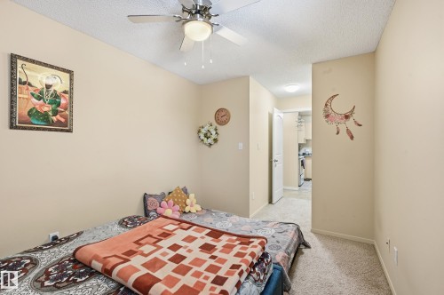 Bedroom featuring a textured ceiling, light carpet, and a ceiling fan - 302 2624 Mill Woods Road E, Edmonton, AB - Indoor Photo Showing Bedroom