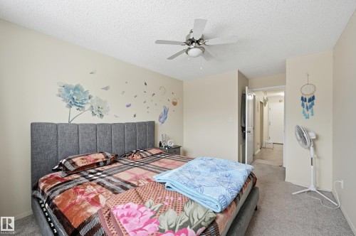 Bedroom featuring light carpet, ceiling fan, and a textured ceiling - 302 2624 Mill Woods Road E, Edmonton, AB - Indoor Photo Showing Bedroom