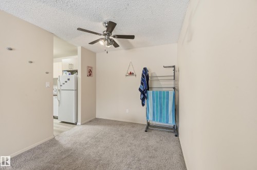 Empty room featuring light colored carpet, a textured ceiling, and a ceiling fan - 302 2624 Mill Woods Road E, Edmonton, AB - Indoor Photo Showing Other Room