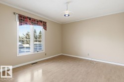 Spare room featuring light wood finished floors and crown molding - 