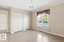 Unfurnished bedroom featuring multiple closets, crown molding, light wood-style floors, and a textured ceiling - 