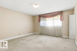 Carpeted empty room featuring baseboards and a textured ceiling - 