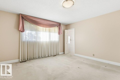 Carpeted empty room with baseboards and a textured ceiling - 14335 47 Avenue, Edmonton, AB - Indoor Photo Showing Other Room
