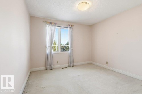 Carpeted spare room with baseboards and a textured ceiling - 14335 47 Avenue, Edmonton, AB - Indoor Photo Showing Other Room