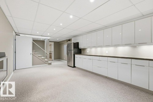Kitchen with white cabinets, a paneled ceiling, light colored carpet, freestanding refrigerator, and recessed lighting - 14335 47 Avenue, Edmonton, AB - Indoor Photo Showing Other Room