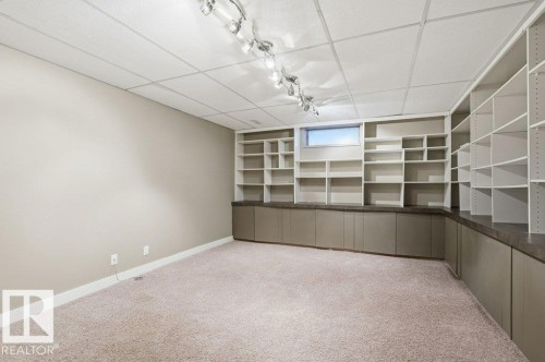 Finished below grade area with light colored carpet, a paneled ceiling, and rail lighting - 14335 47 Avenue, Edmonton, AB - Indoor