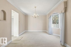 Unfurnished room with hanging lights, light carpet, crown molding, and a textured ceiling - 