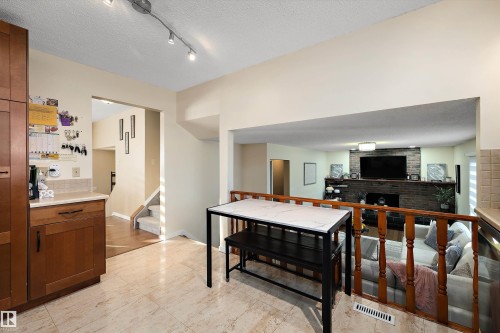Living area featuring a textured ceiling, track lighting, and a fireplace - 9804 156 Avenue, Edmonton, AB - Indoor Photo Showing Other Room