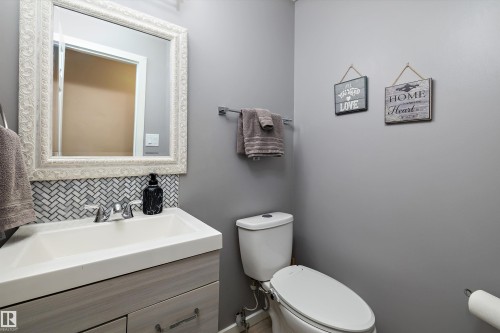 Half bath featuring vanity and tasteful backsplash - 9804 156 Avenue, Edmonton, AB - Indoor Photo Showing Bathroom