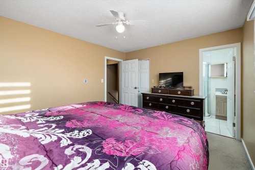 Bedroom featuring carpet flooring, a textured ceiling, ensuite bath, and ceiling fan - 9804 156 Avenue, Edmonton, AB - Indoor Photo Showing Bedroom