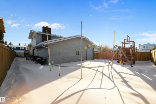 Back of property featuring a playground, a fenced backyard, a chimney, and a patio - 9804 156 Avenue, Edmonton, AB - Outdoor