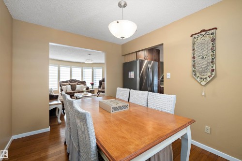 Dining space with dark wood-type flooring, a textured ceiling, and a desk - 9804 156 Avenue, Edmonton, AB - Indoor Photo Showing Dining Room