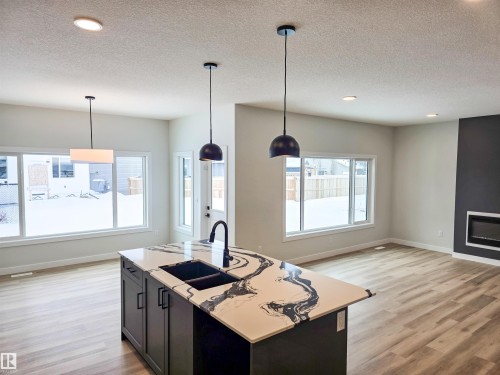 219 Ravine Drive, Devon, AB - Indoor Photo Showing Kitchen With Fireplace With Double Sink