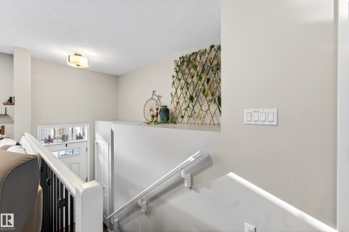 Staircase featuring an upgraded railing. - 103 3305 Orchards Link Link, Edmonton, AB - Indoor Photo Showing Other Room