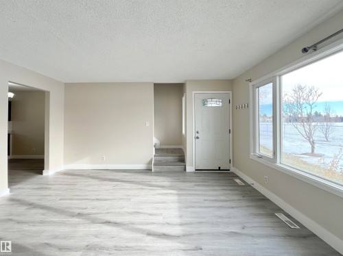 Foyer entrance with light wood-style flooring and a textured ceiling - 11357 22 Avenue, Edmonton, AB - Indoor Photo Showing Other Room