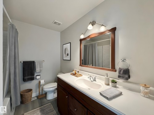 Full bath featuring vanity, shower / bath combo, and dark wood-style floors - 11357 22 Avenue, Edmonton, AB - Indoor Photo Showing Bathroom