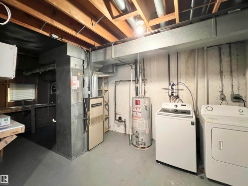 Unfinished basement featuring gas water heater and washer and clothes dryer - 11357 22 Avenue, Edmonton, AB - Indoor Photo Showing Laundry Room