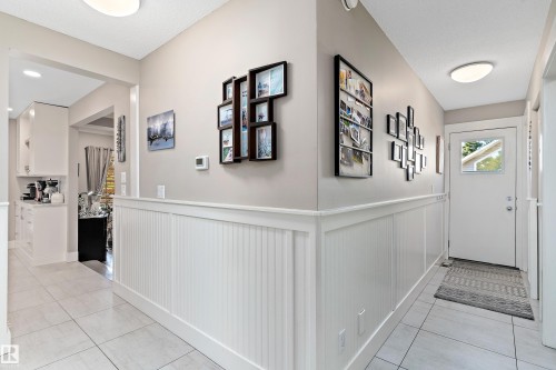 Hallway featuring light tile patterned flooring and a wainscoted wall - 317 Grand Meadow Crescent, Edmonton, AB - Indoor Photo Showing Other Room
