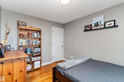 Bedroom featuring light wood finished floors and a textured ceiling - 317 Grand Meadow Crescent, Edmonton, AB - Indoor