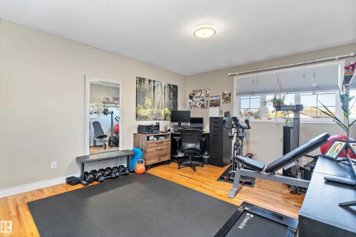 Office area with a textured ceiling and light wood finished floors - 317 Grand Meadow Crescent, Edmonton, AB - Indoor Photo Showing Gym Room