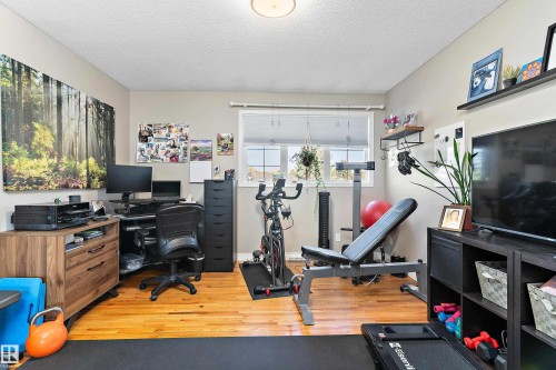 Home office with a textured ceiling and light wood-style flooring - 317 Grand Meadow Crescent, Edmonton, AB - Indoor Photo Showing Gym Room